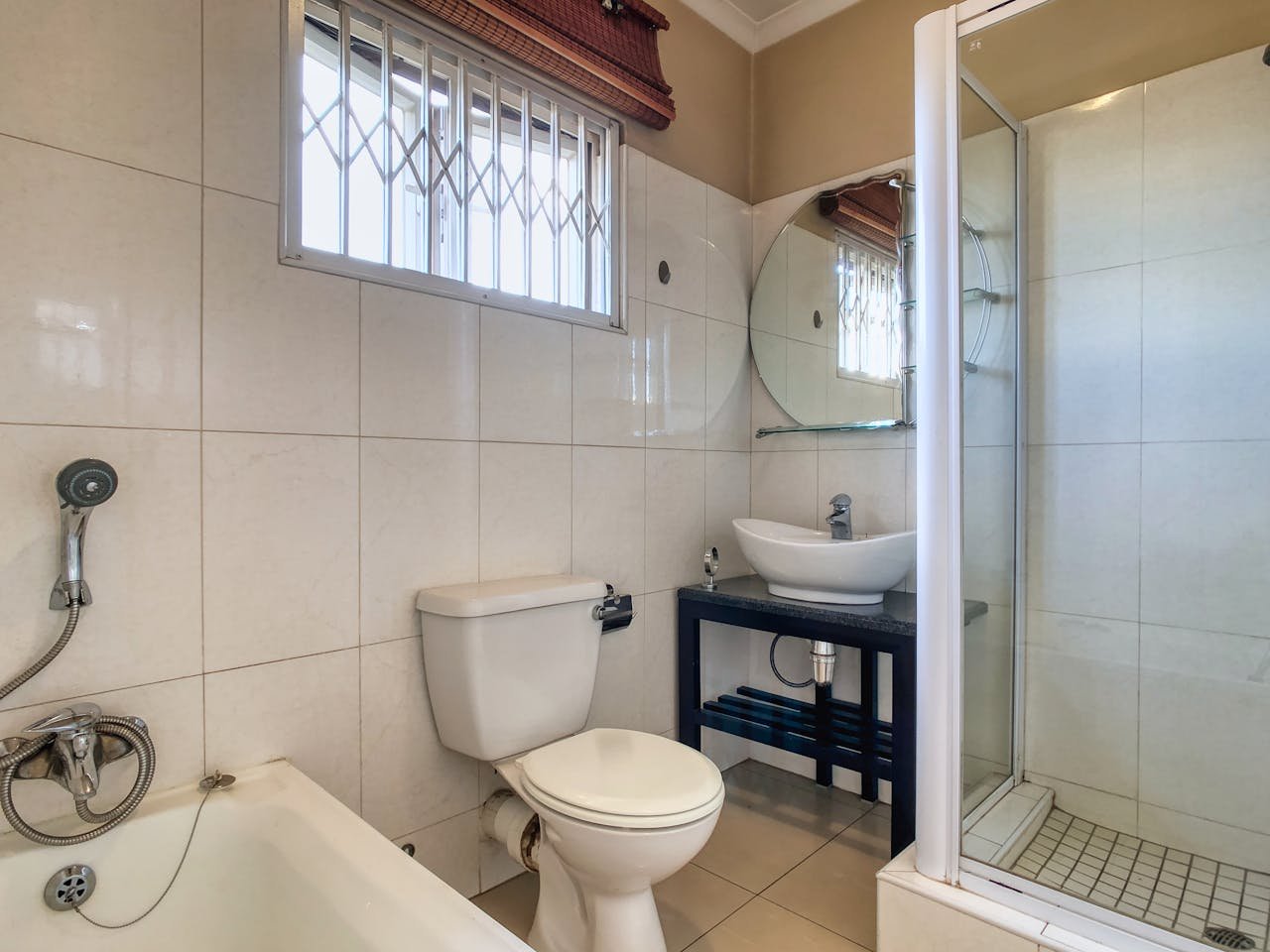 A stylish bathroom interior featuring a shower, bathtub, sink, and modern fixtures.